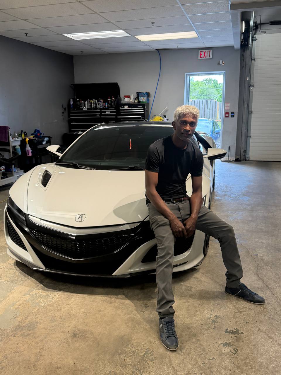 Dinesh of Double M Auto Detailers with a freshly detailed luxury sports car